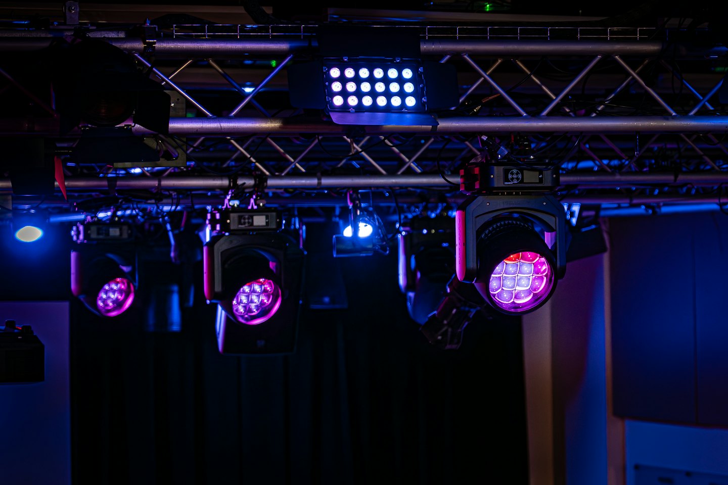 Professional stage lights mounted on a metal rigging truss system.