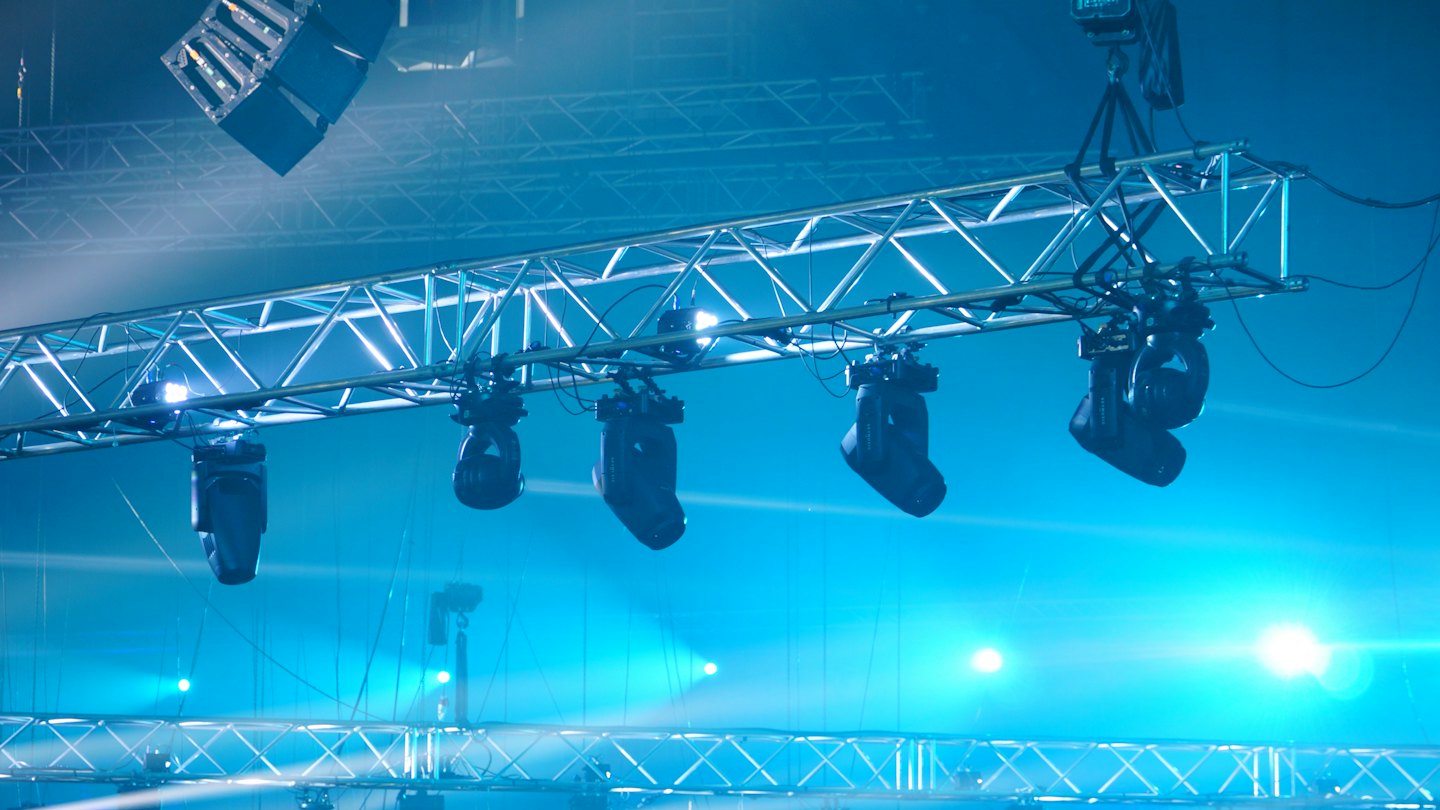 Professional stage lights and speakers mounted on metal trusses.