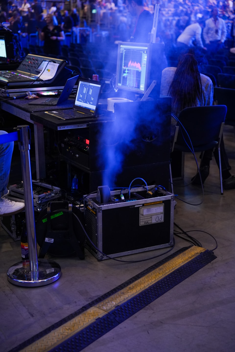 Event technician mixing sound and lighting at a console.