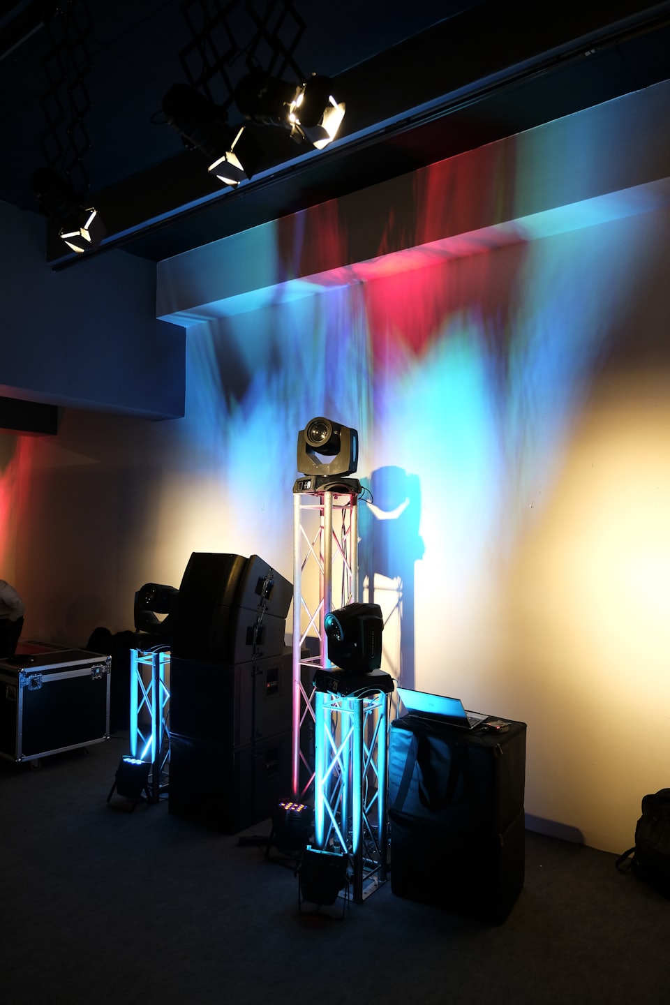Stage lighting and sound equipment in a dark venue with colored lights.